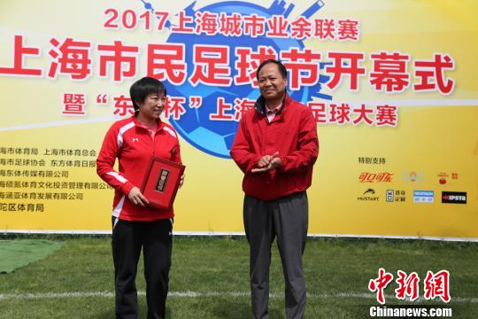 5月6日,上海市体育局副局长赵光圣为著名足球运动员孙雯,颁发市民足球节推广大使聘书。 组委会供图 摄