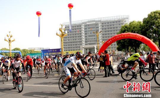 图为骑手沿着风景如画的高邮湖畔骑行并展开激烈角逐。 崔佳明 摄