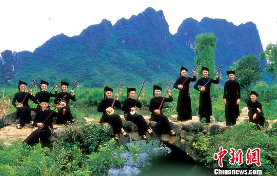 天琴是一种古老的壮族乐器,该项乐器技艺自古以来在广西龙州县代代流传,并发展成为当地独有的文化符号。图为广西龙州县天琴女子弹唱组合。 严造新 摄