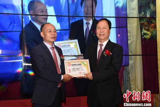 图为中国全国政协港澳台侨委员会副主任焦焕成(右)为巴西华人协会连任会长朱苏忠颁发任职证书。 莫成雄 摄