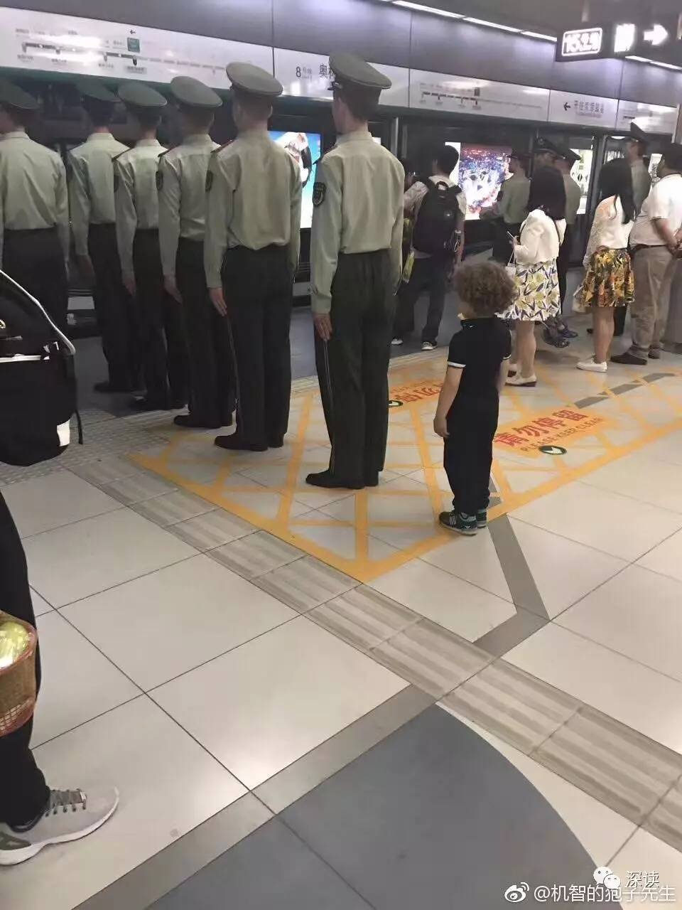 图为网上热传“榜样的力量”照片，在奥林匹克公园站小男孩学习武警战士列队立正等车