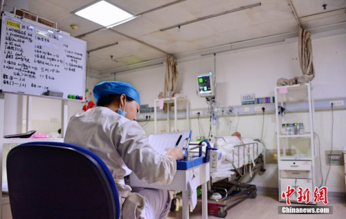 资料图:2017年4月19日,是山西医科大学第一医院神外重症监护室(NICU)责任护士婷婷上班以来的第490个夜班。27岁的她不再畏惧黑夜,但老公还是放心不下,必须亲自送她去上班。凌晨1点,责任护士婷婷正在埋头奋笔疾书,她本科毕业后从事护理行业四年,期间在ICU干了1056天,没有法定节假日。 王明宇 摄