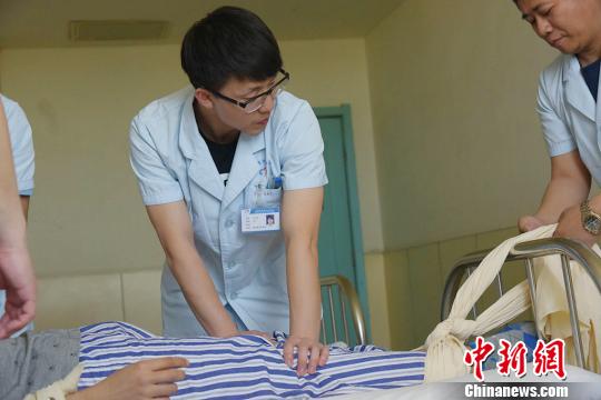 与精神分裂症女科患者吐口水、用指甲挠人相比,普通精神科男科的病人更具有攻击性。5月10日,张宝田和他的同事正在对一个狂躁症发作的患者进行约束保护。 范丽芳 摄