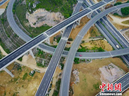 图为航拍花安(贵阳市花溪至安顺市)高速公路终点小屯互通枢纽,纵横交错的路网宛如血管。 贺俊怡 摄