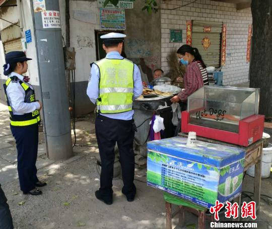 图为民警向街头市民询问老人的家人和住址。 周国芮 摄