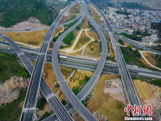 图为航拍花安(贵阳市花溪至安顺市)高速公路终点小屯互通枢纽,纵横交错的路网宛如血管。 贺俊怡 摄