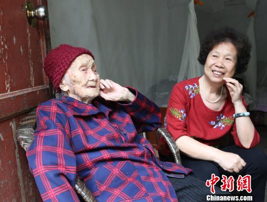 李桂昭在唱山歌,逗笑孙女谢汉惠。 朱柳融 摄