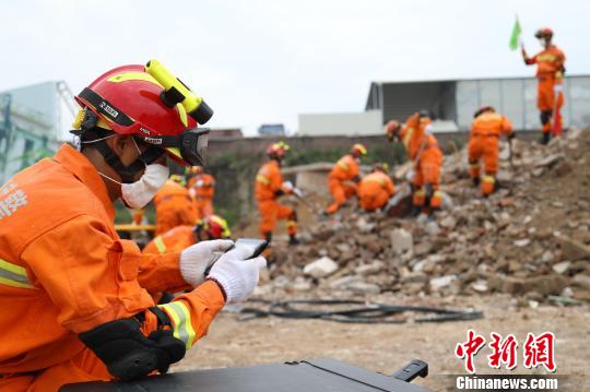 图为武警龙岩支队救援分队官兵在应急演练现场利用生命探测仪进行探测。(龙岩武警供图) 张斌 摄