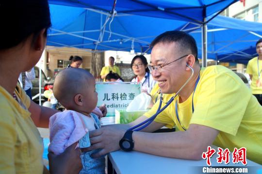 图为医护人员仔细为患儿进行术前筛查。 楚哲 摄