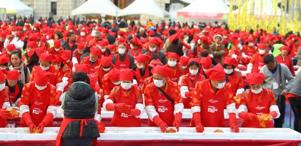 资料图片：2015年10月31日，在韩国首尔市厅广场，中国游客在体验制作泡菜。新华社记者 姚琪琳 摄