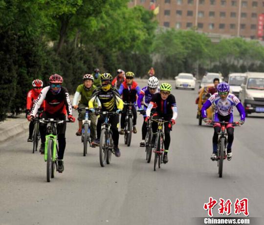 图为中外骑友在兰州休闲骑行,倡导全民健身与绿色出行理念。 崔琳 摄