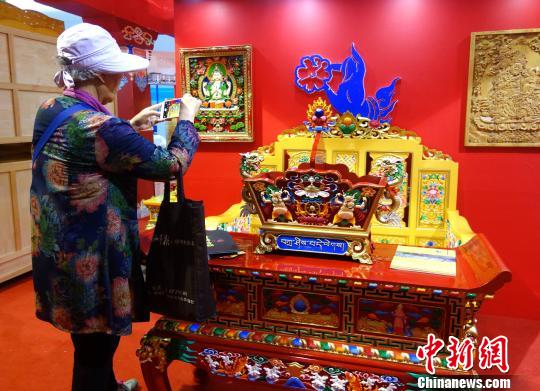 图为参展的青海藏式家具吸引西安市民拍照。 孙睿 摄