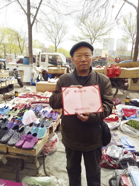 老人展示荣誉证书