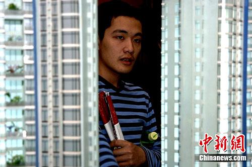 资料图:一位年轻人早早来到福州一售楼部看楼盘。中新社记者 王东明 摄