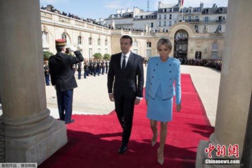 资料图：5月14日，在法国巴黎爱丽舍宫，当选总统马克龙与夫人布丽吉特·特罗尼厄在权力交接后步入爱丽舍宫。