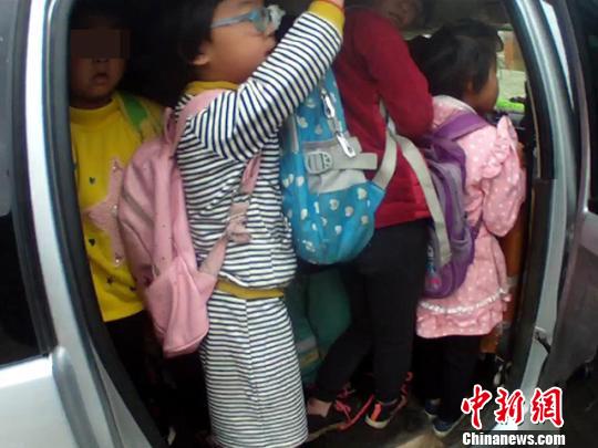 乘坐超载车辆的幼儿园学生们。　张忠扩 摄