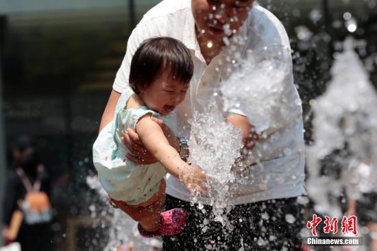 5月17日，热浪来袭，北京正式开启炎炎夏日节奏。图为一名儿童在北京三里屯喷泉处玩耍。 中新社记者 李慧思 摄