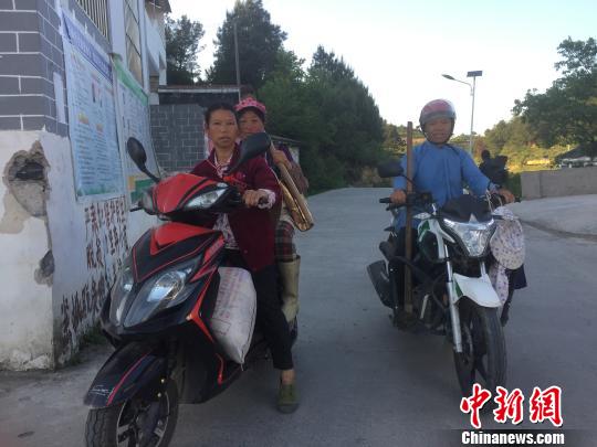 下午时分,村民骑着摩托车扛着锄头下班回家。 刘鹏 摄