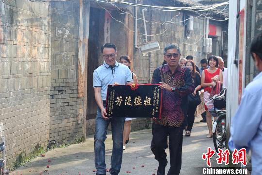 图为丁伟强与儿子向上杭丁氏宗族敬献“祖德流芳”牌匾。 郑嘉雯 摄