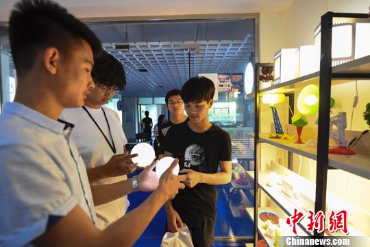 5月16日,江西新余学院一名大学生为顾客3D打印定制纪念品。 赵春亮 摄