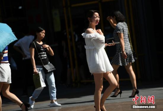 5月17日,观音桥步行街上美女着凉装出行。<a target=\'_blank\' href=\'http://www.chinanews.com/\'>中新社</a>记者 陈超 摄