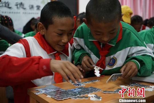 5月18日,拉萨市姜昆黄小勇希望小学的学生们体验文物拼图游戏。 赵玉芹 摄