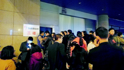 在学而思组织的一次模拟考试中，数以千计的家长晚上聚集在济南金龙大厦狭窄的出口处，等着接孩子回家。（资料片）