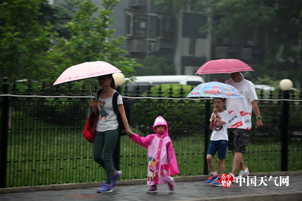 22日8时许,北京城区降下小雨,行人冒雨出行。(赵嫣嫣摄)