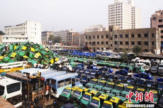 图为报废汽车存放地,当地将对它们进行循环再利用。 钟欣 摄