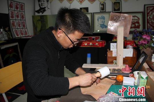 图为魏康龙正在制作皮雕。 杨东东 摄