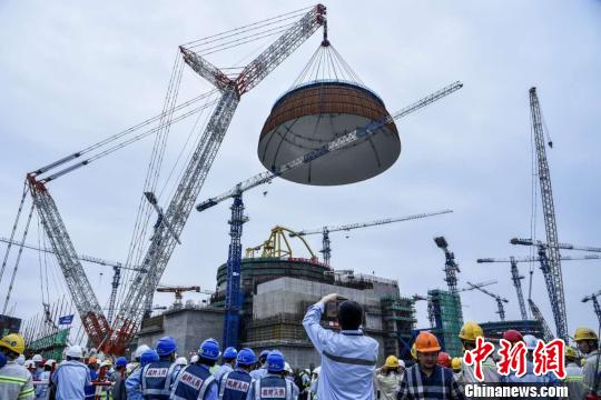 5月25日下午5时58分,中国自主三代核电“华龙一号”全球首堆示范工程——中核集团福清核电5号机组穹顶吊装成功,这标志着5号机组已全面进入设备安装阶段。 钟鹰 摄