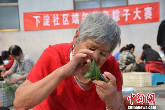 这位年近八旬的奶奶包起粽子,绝不亚于当年风采。 朱志庚 摄