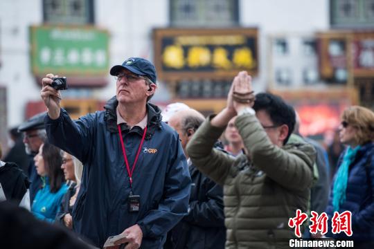 图为5月26日,西藏宗教节日”萨嘎达瓦“首日,外国游客在大昭寺前拍照留念。 何蓬磊 摄