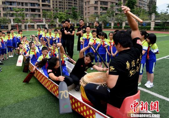 来自华侨大学龙舟队的队员们为学生们讲解、示范龙舟赛及挥桨要领。 记者刘可耕 摄