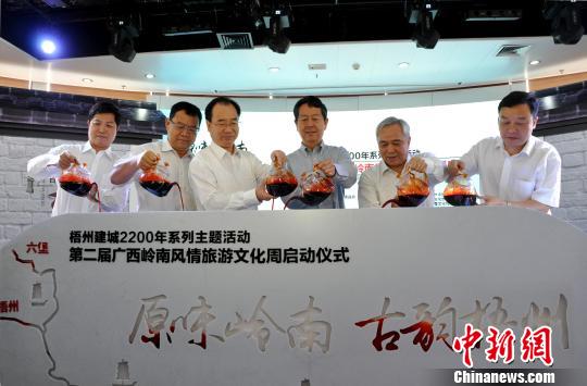 图为嘉宾将梧州六堡茶注入启动台,以茶船古道示意图来启动活动周。 黄艳梅 摄