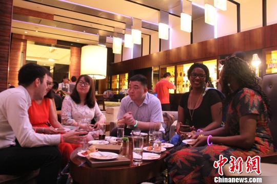 图为中国海外留学归国人员与在华外国朋友交谈。 曾洁 摄