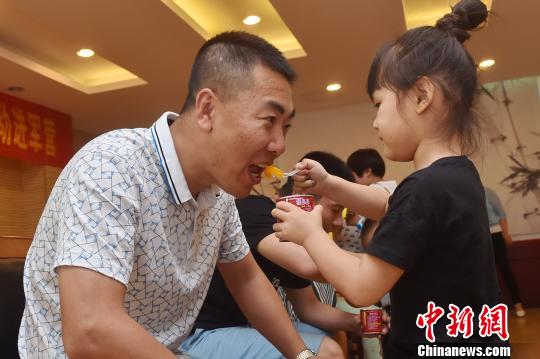 官兵子女喂“英雄父亲”吃东西。 沈灿煌 摄