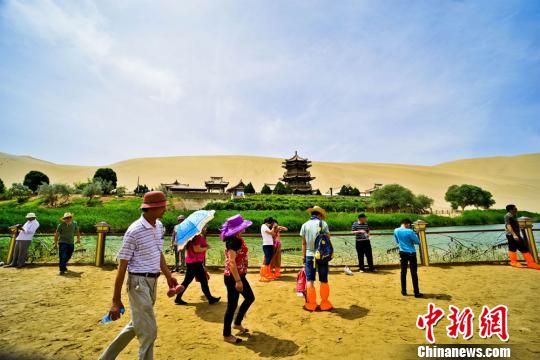 图为美丽的月牙泉吸引游人驻足欣赏“大漠水景”。 王斌银 摄