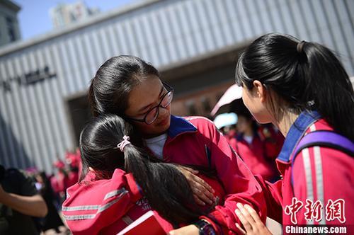 资料图:内蒙古高中生毕业典礼 同学拥抱惜别。<a target=\'_blank\' href=\'http://www.chinanews.com/\'>中新社</a>记者 刘文华 摄
