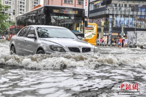 资料图：5月24日，广州江燕路，一辆汽车通过路段低洼积水处。中新社记者 陈骥旻 摄