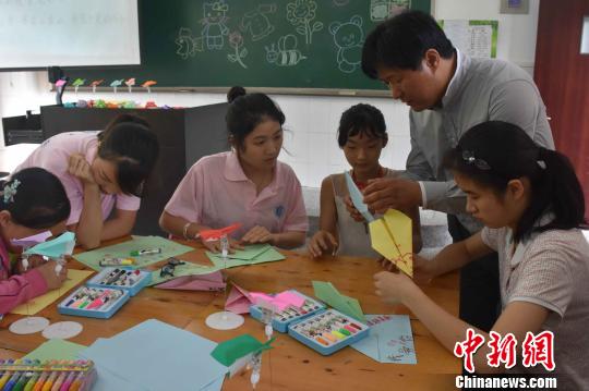 老师指导特殊学校孩子折纸飞机 西南大学