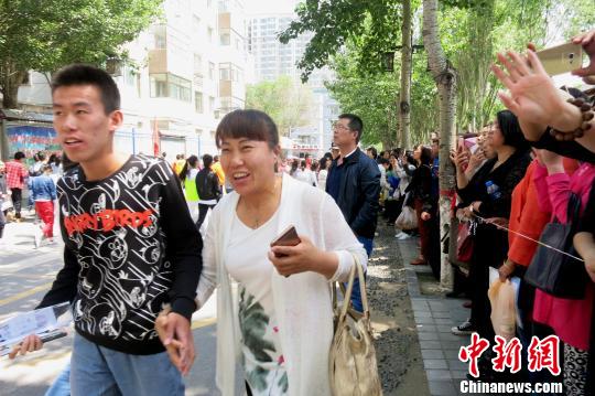 图为首门考试结束,考生走向等待在外的家长。 张海雯 摄