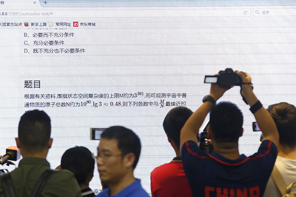 媒体记者在观看高考机器人AI-Maths答北京文科数学卷（图片来自：澎湃新闻）