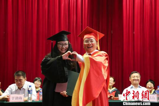 “合体比个心。”学生和院长“合体比心”拍照留念。 钟欣 摄