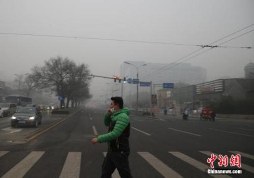  资料图：一名戴着口罩的行人走在北京街头。中新社记者 张浩 摄