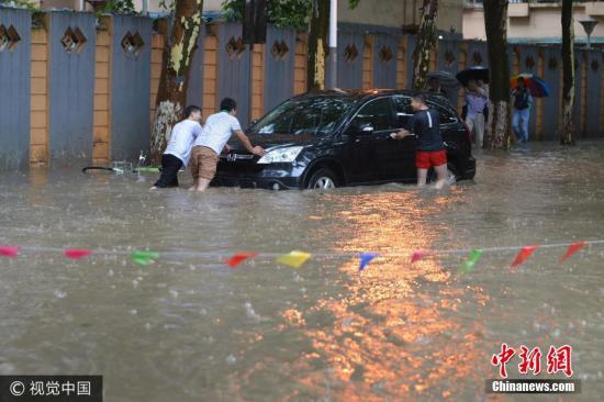 图为6月10日，南京市雨花台区，几个男子推着抛锚的汽车。文字来源：中国天气网 图片来源：视觉中国