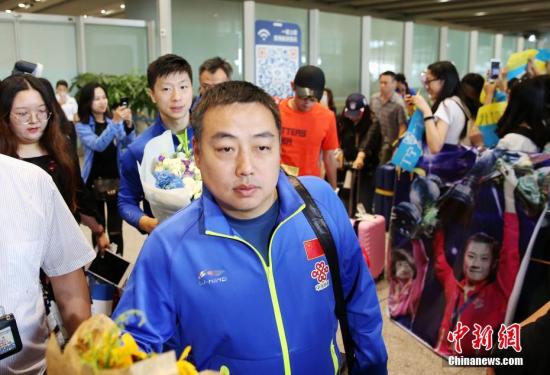 资料图：中国乒乓球队总教练刘国梁（前）抵达北京首都国际机场，球迷热情迎接。第54届世界乒乓球锦标赛中国队囊获了男女单打与男女双打共四个项目的冠军。 中新社记者 卞正锋 摄