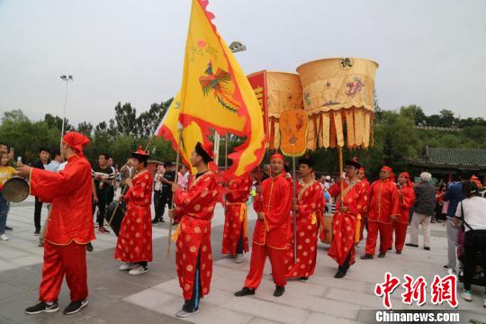 图为“迎亲”队伍走过广场。 郑兵 摄