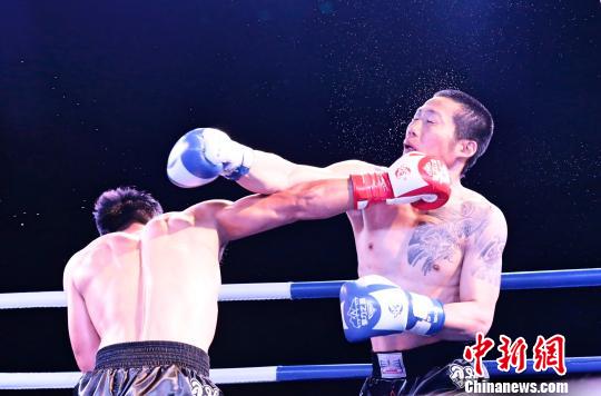 图为中国选手刘天军(左)与日本选手上妻慎治在自由搏击68KG级比赛中对决,最终由刘天军获胜。 胡贵龙 摄