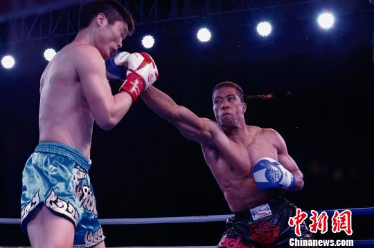 图为中国选手吕二飞(左)与美国选手爱立信在自由搏击75KG级比赛中对决,最终由吕二飞获胜。 胡贵龙 摄